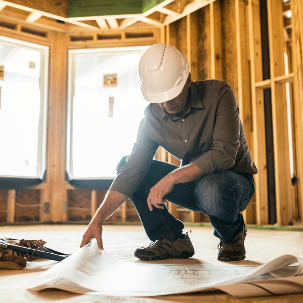 man working on the construction with plan